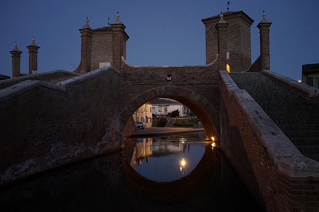 The canals and stunning architecture of Comacchio at night ...