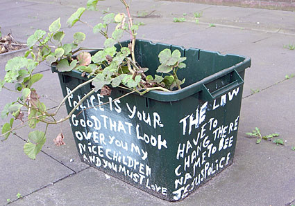 Slogans on plant pots outside Brixton Police Station, Gresham Road,  Brixton, Lambeth, London SW9