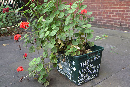 Slogans on plant pots outside Brixton Police Station, Gresham Road,  Brixton, Lambeth, London SW9