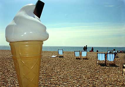 Giant ice cream cone, deckchairs and beach on the Brighton seafront, East Sussex