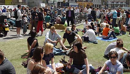 People relax on the grassy lawn created on St John Street, Smithfield, London