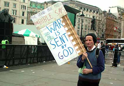 Religious anti-war protester holding baffling placard